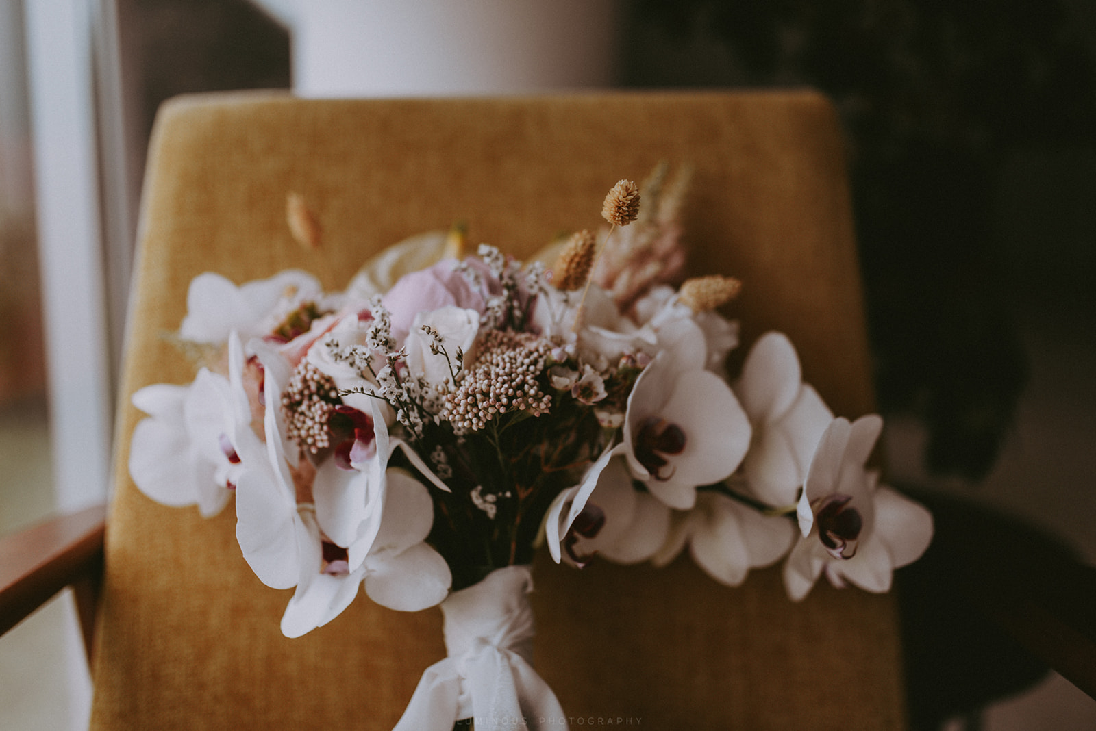 bridal bouquet against seventies chair, orchids and silk ribbon