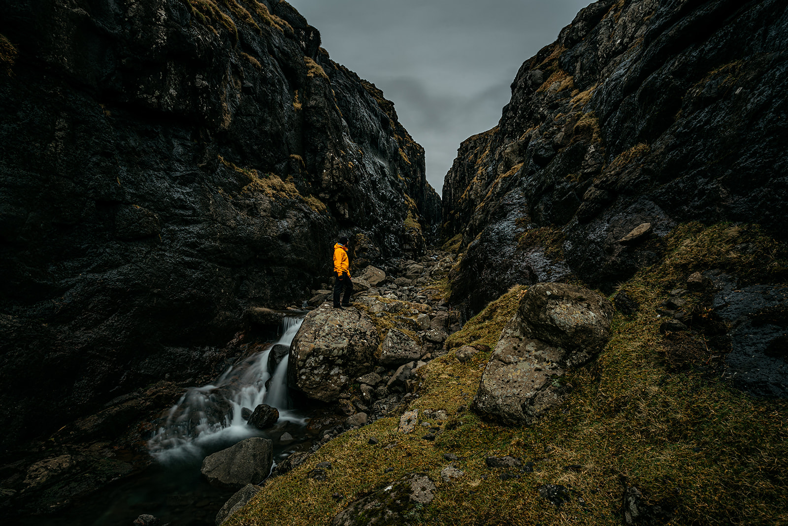 Man in yellow jacket standing in gorge