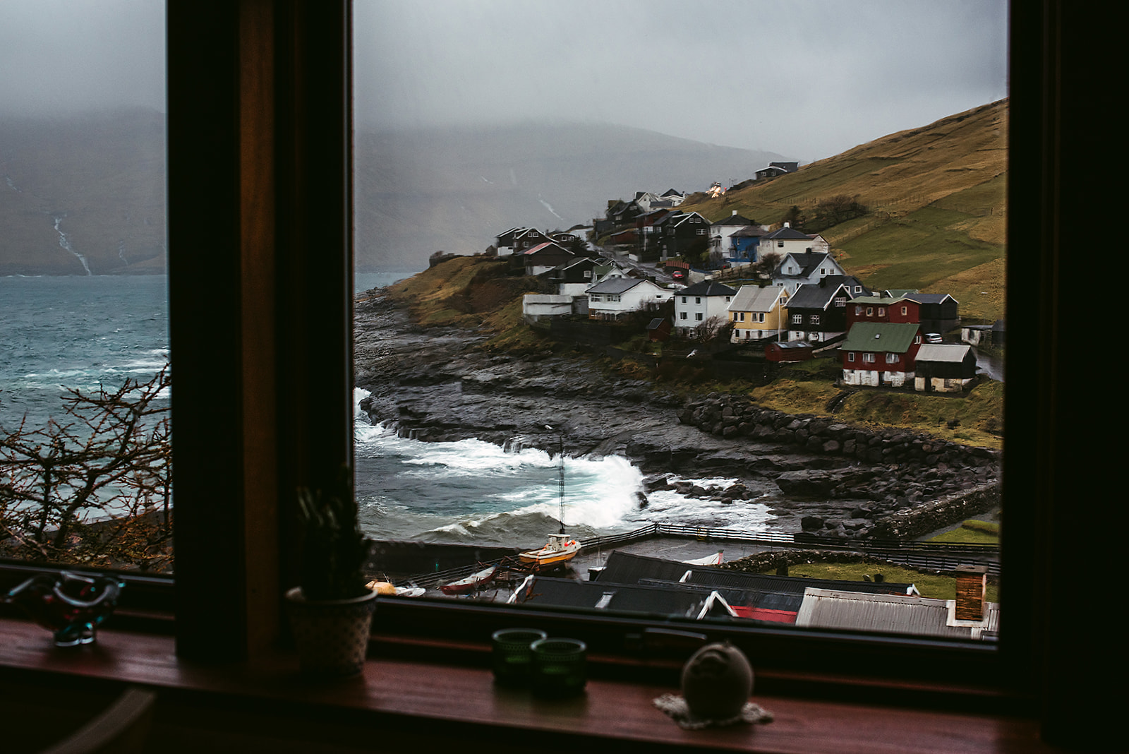 View from the living room on a stormy sea crashing against a small fishermen's village