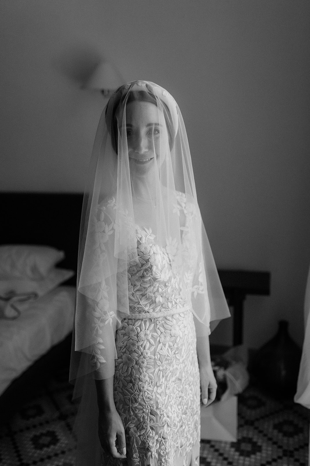 B&W photograph of bride looking at camera with veil over head