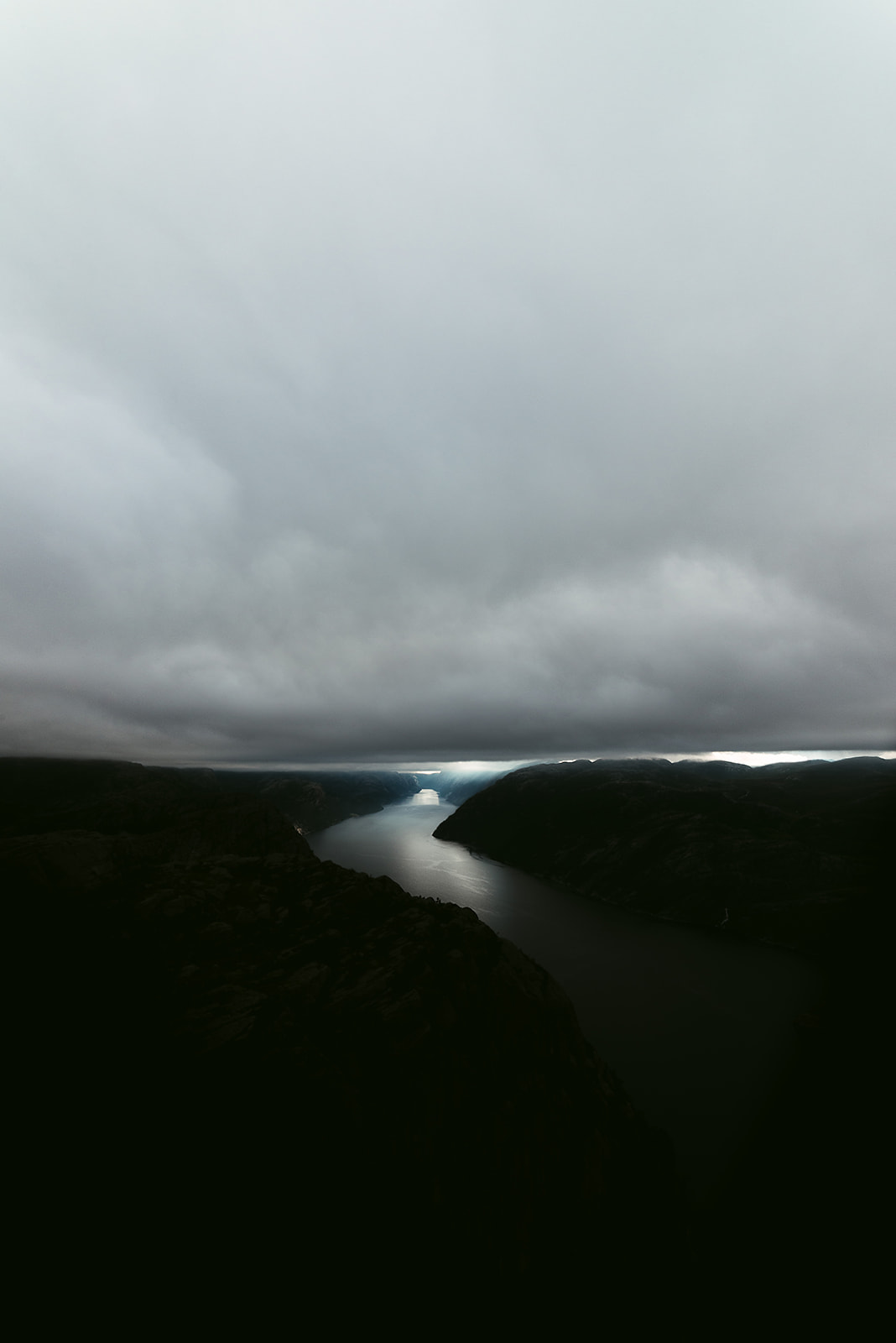 Fjord stretching to the horizon on dark and cloudy day
