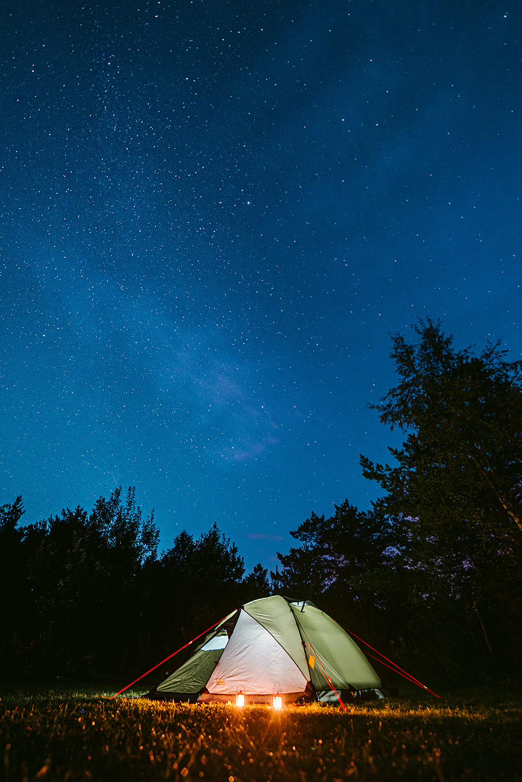 Illuminated tent under a starry night sky