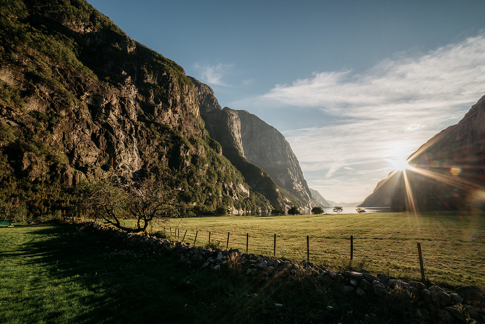 Sunlight hitting a small stone wall on field in a valley
