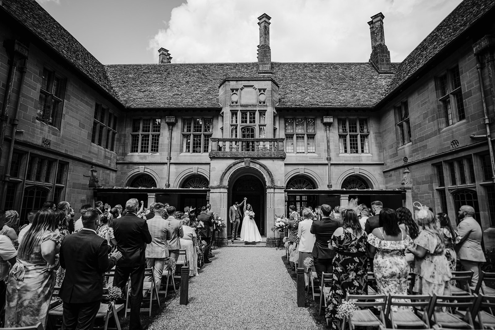 a black and white photograph of a bride punching the air after her outdoor wedding at Coombe Lodge blagdon