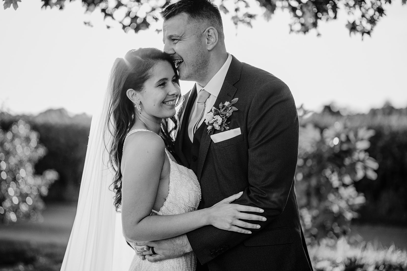 a black and white documentary style picture of a bride and groom at the pear tree purton