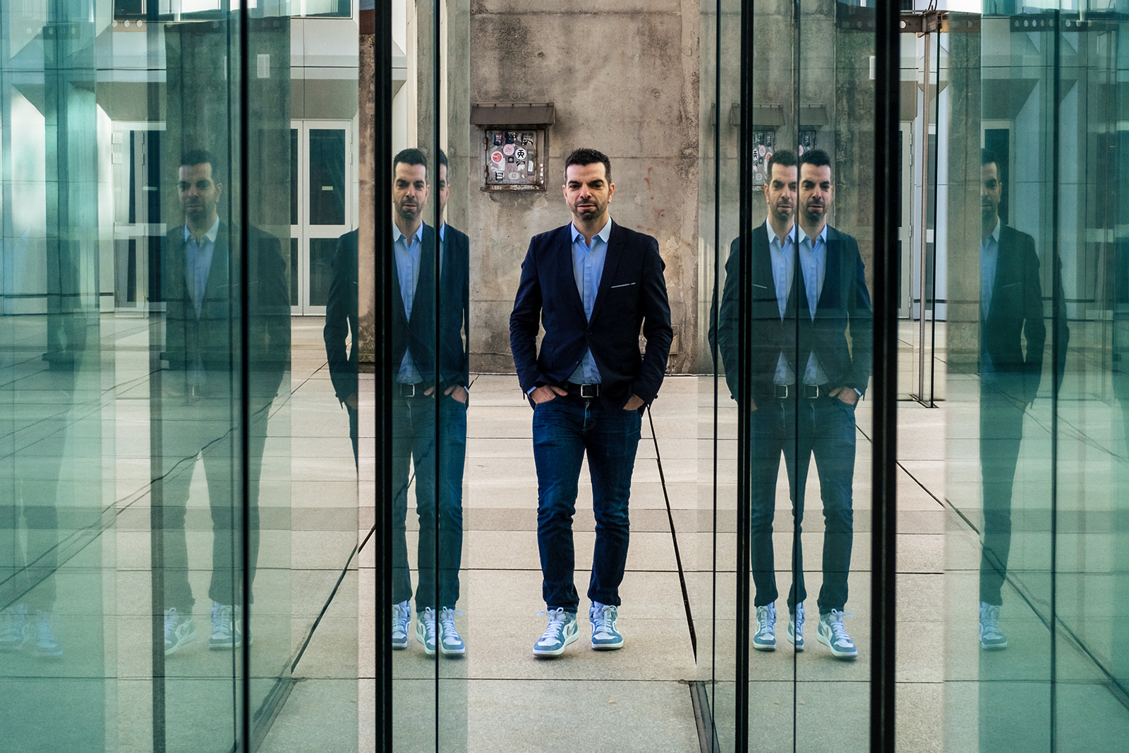 Portrait Jonathan Malka sous la Grande Arche de la Défense avec reflets, Julien Pasternak photographe