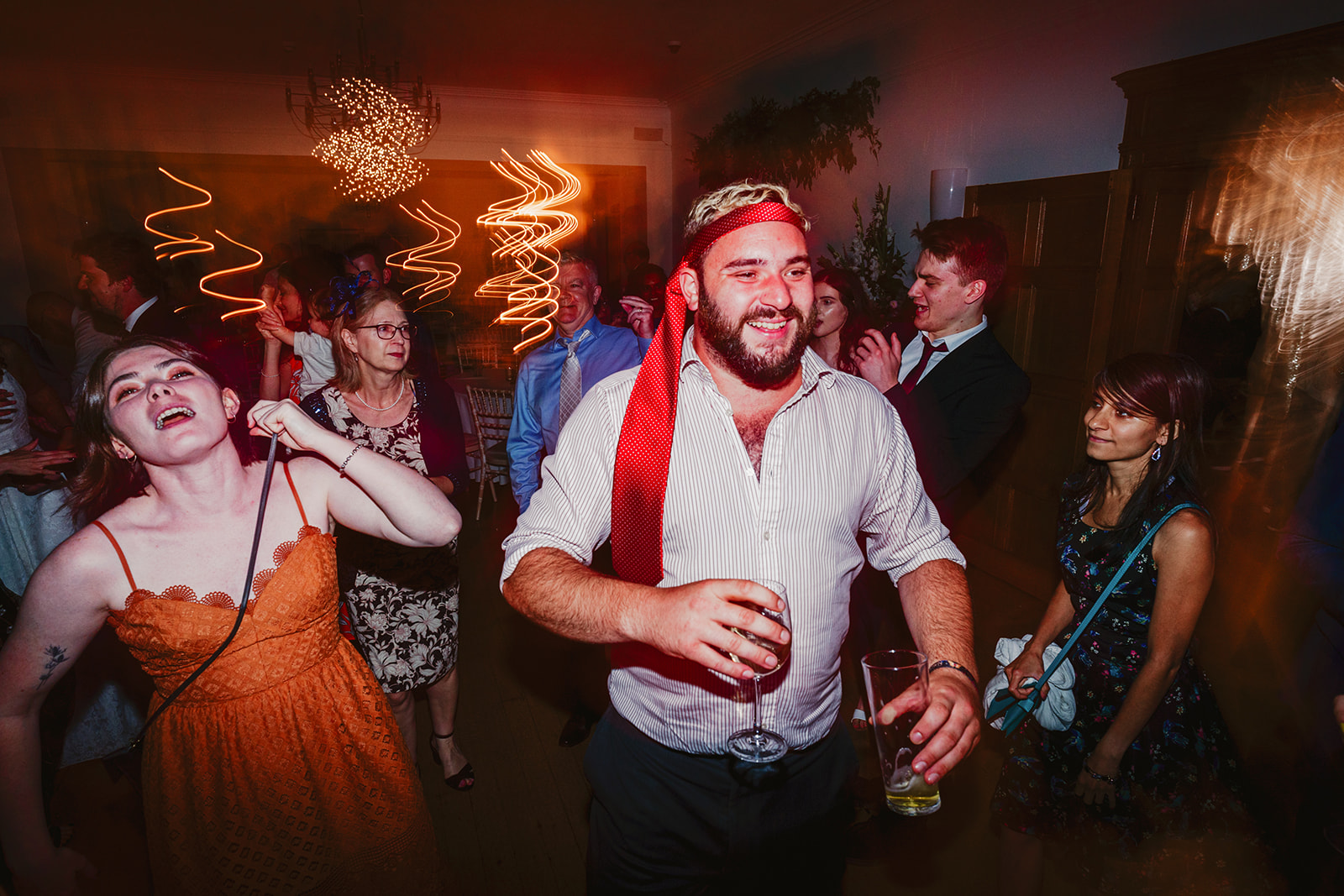 wedding guests dancing with ties on there heads at Coombe Lodge Bristol