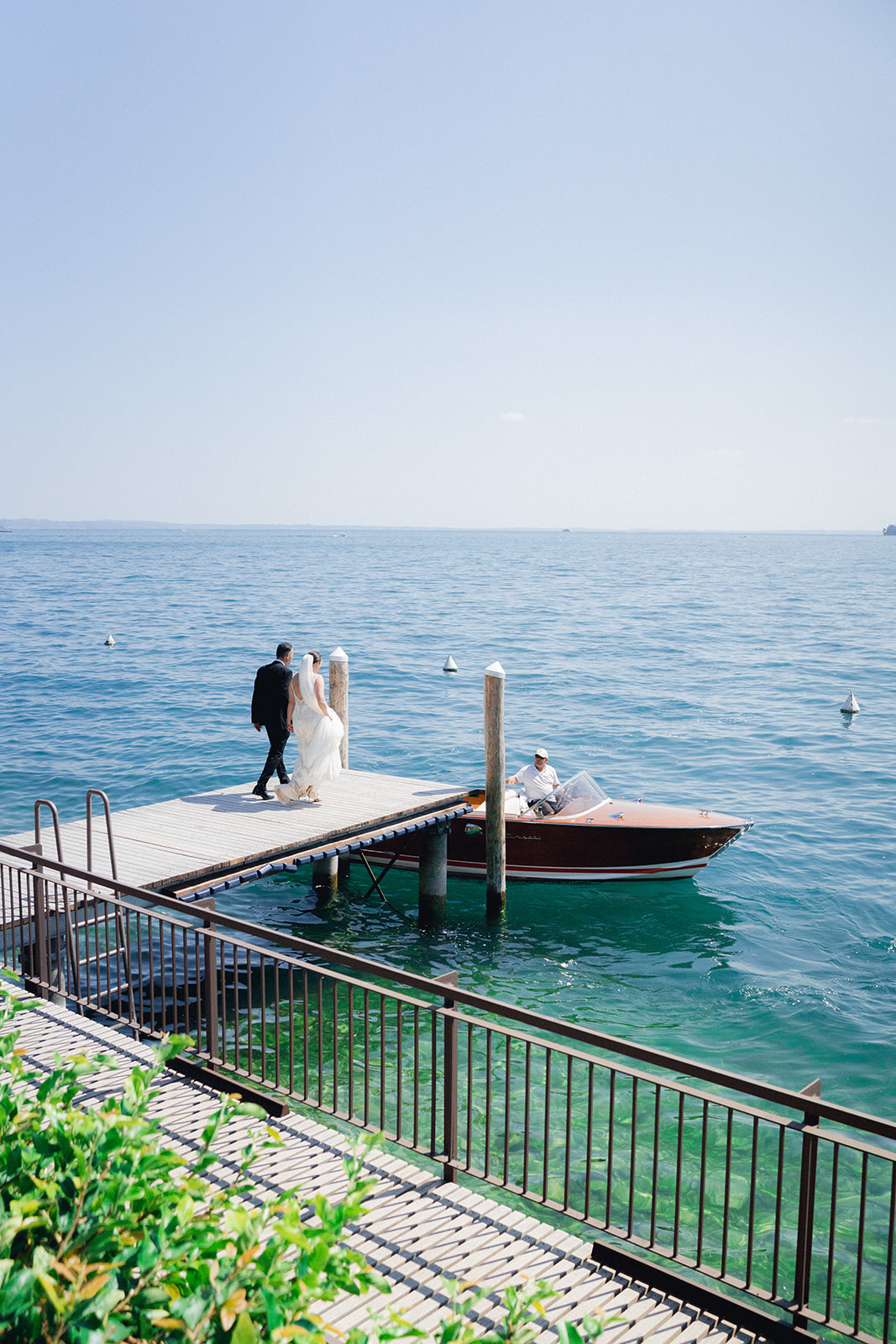 The bride and her father board the boat at the dock of Hotel Bellariva to reach the wedding ceremony at Isola del Garda