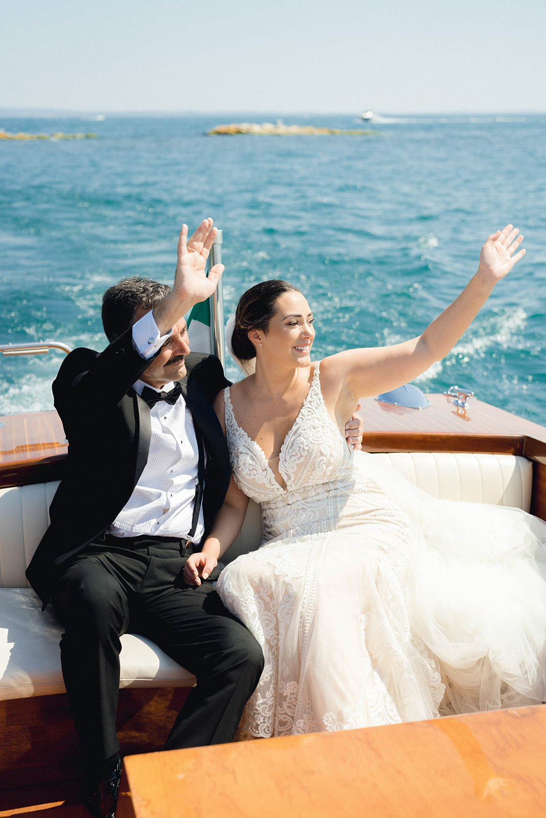 The bride and her father arrive at Isola del Garda by boat and greet the guests who see them arriving at the wedding 