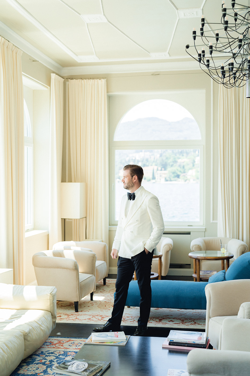 The groom is ready and admires the view of Lake Garda from the lobby of Hotel Bellariva in Riva del Garda