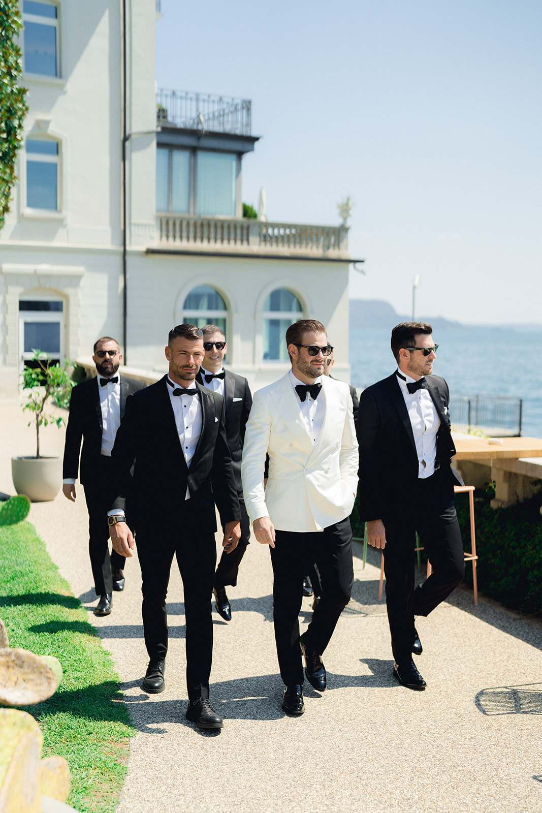The groom & the groomsmen leave Hotel Bellariva dressed in coordinated tuxedos to reach the ceremony in Isola del Garda