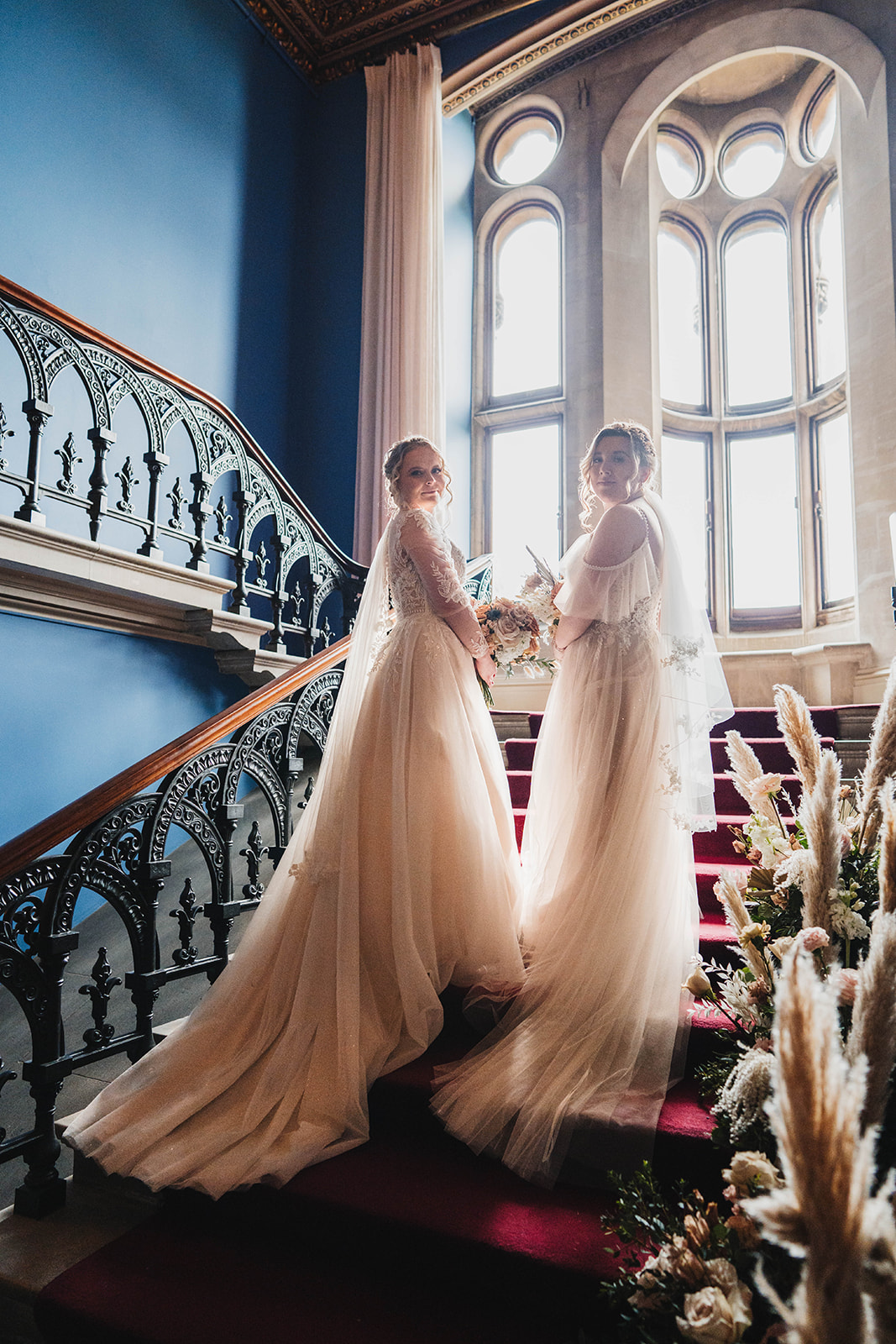 two brides on grand staircase Zara Davis Wedding Photography Cotswolds Grittleton House Gloucestershire Wiltshire