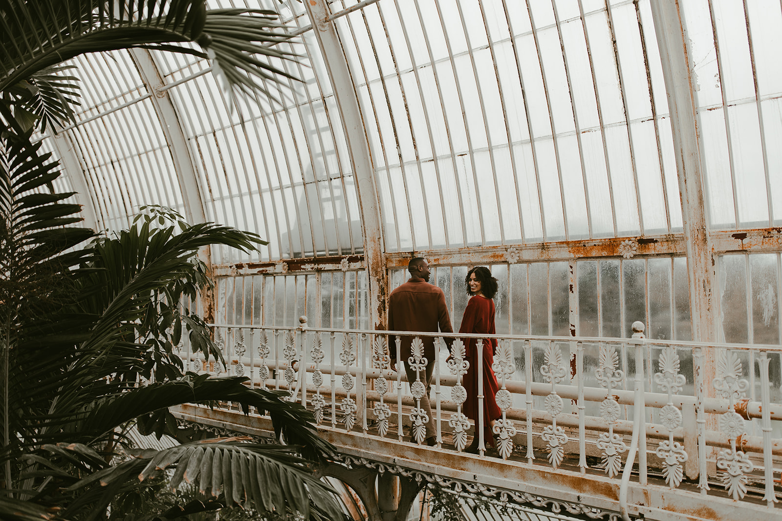 couple explore the beautiful palm house at kew gardens