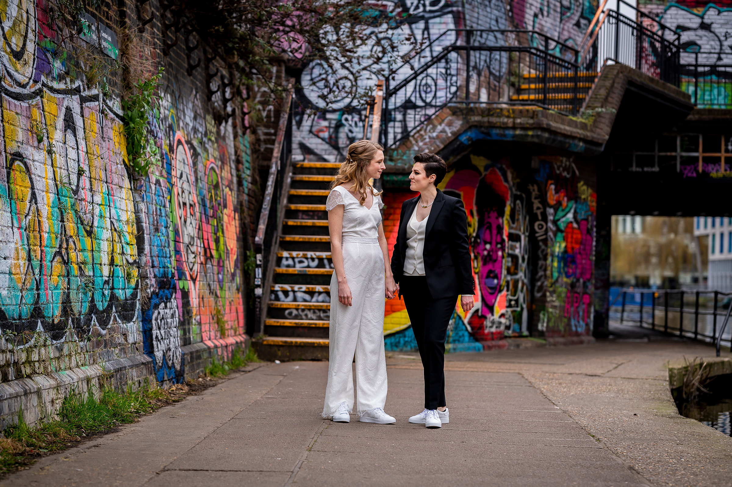 two brides on Regents Canal in London with stunning street art