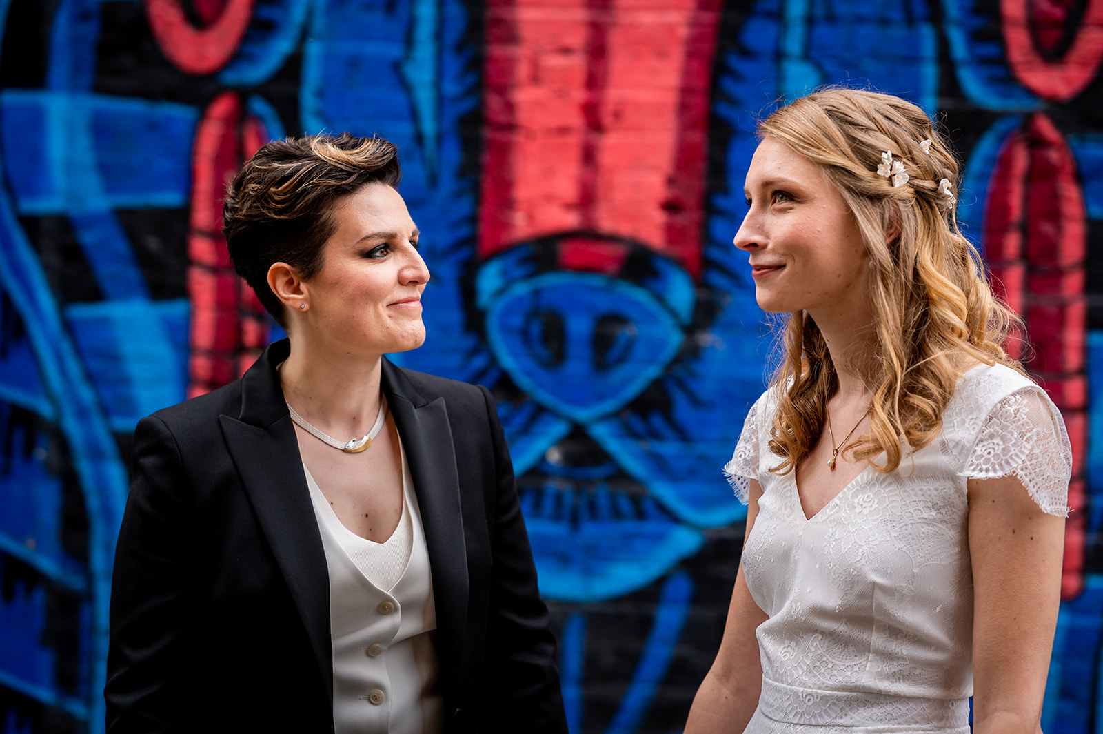 two brides standing in front of vibrant street art