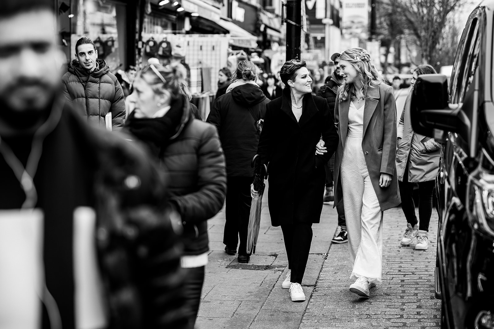 two vibrant brides walking down the street in Camden