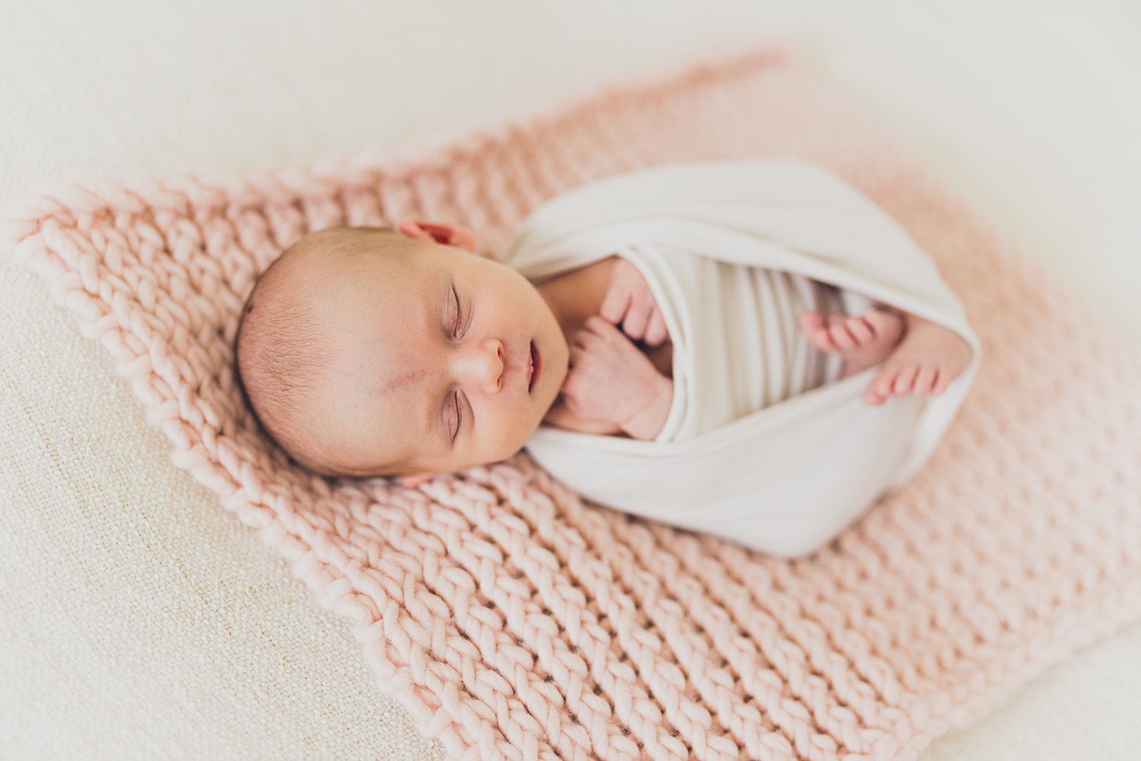 Newborn baby on a beautiful pink knitted blanket at RinkaDink Studio Belfast Northern Ireland