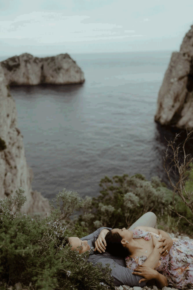 Wunderbares Paar liegend bei einer Bucht im Rahmen eines Foto Shootings auf der Insel Capri in Italien