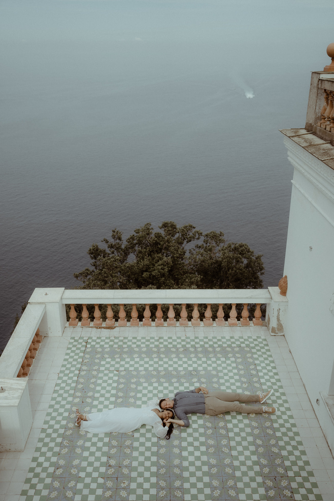 Couple lying on beautiful tiles of Villa Lysis in front of the sea on the island of Capri