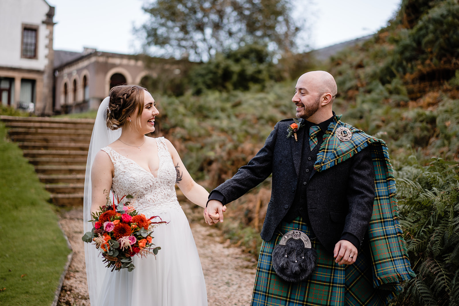 A couple who married at Gleddoch Golf & Spa Resort holding hands and laughing.