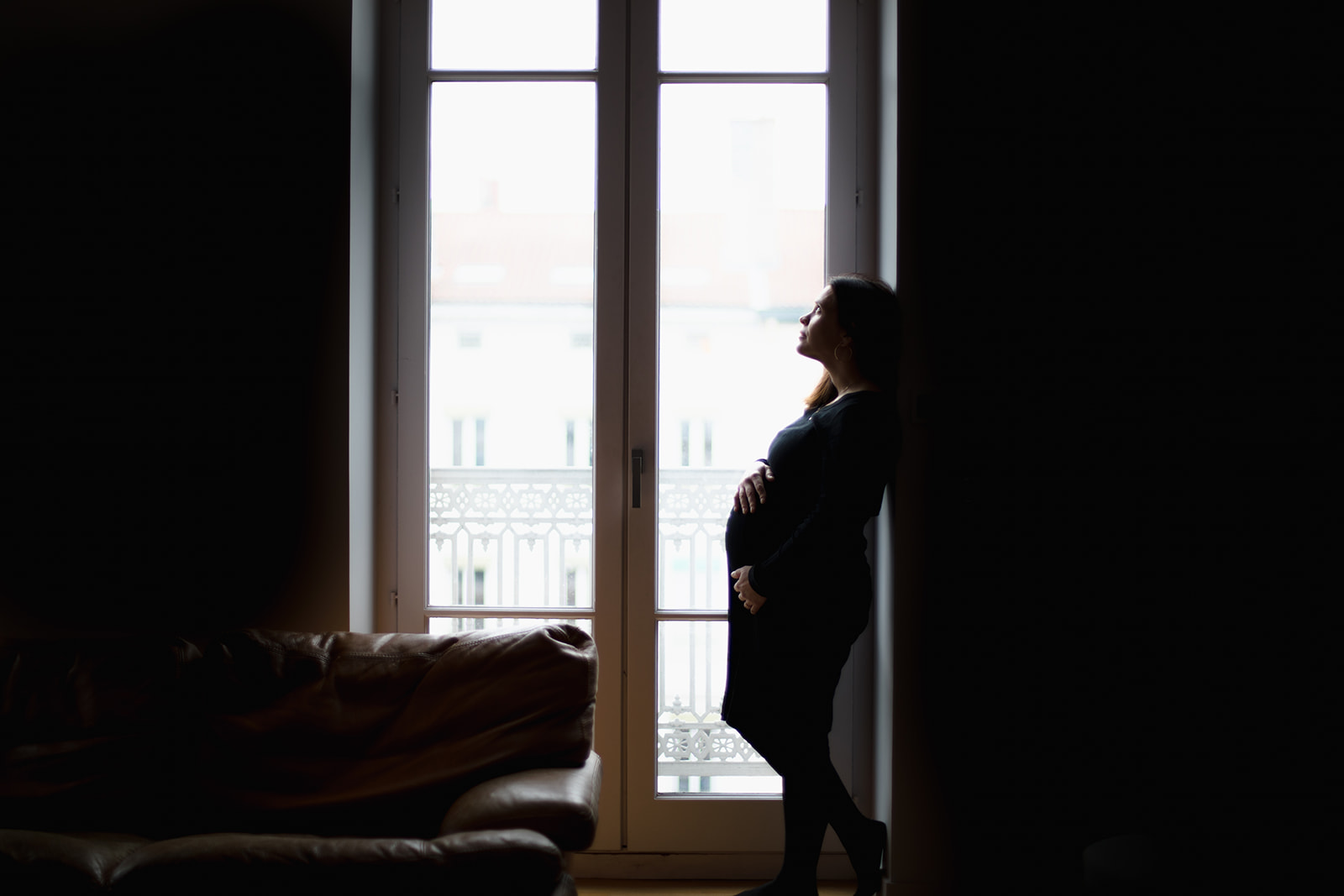 Séance photo d'une femme enceinte dans son domicile à Lyon, le long de sa baie vitrée