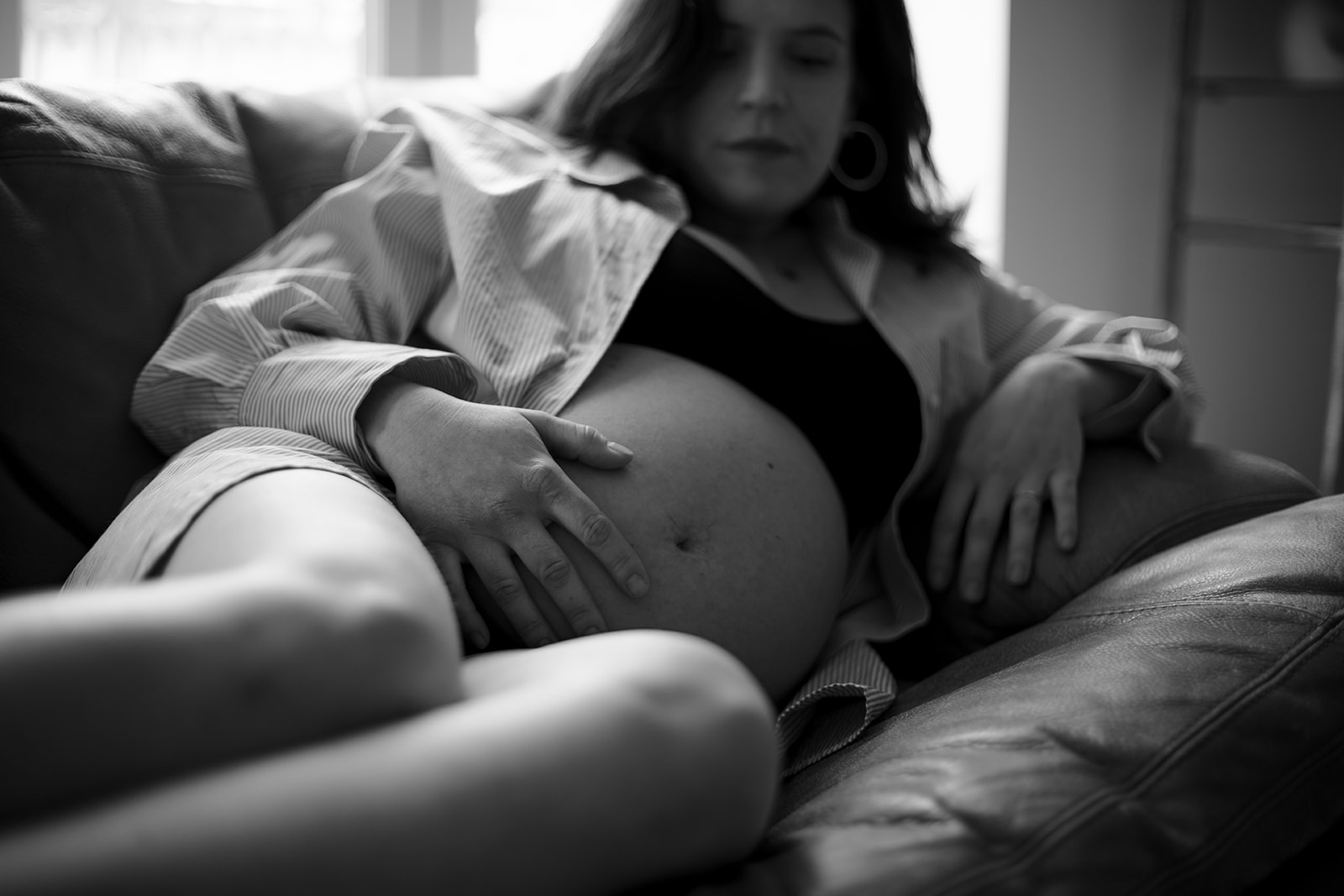 Séance photo d'une femme enceinte dans son domicile à Lyon, en lingerie, photo en noir et blanc.