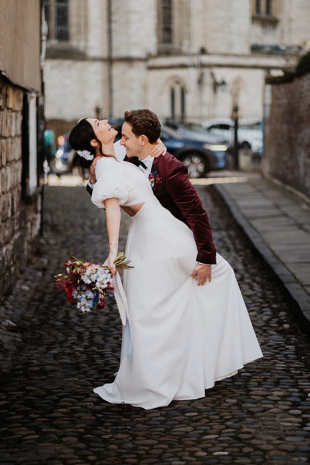 Couple on the cobbled street of York for their Winter City Elopement with hydrangea bouquet