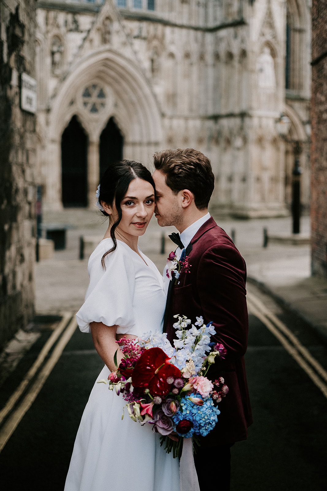 Couple outside of York Minster for their Winter City Elopement with hydrangea bouquet