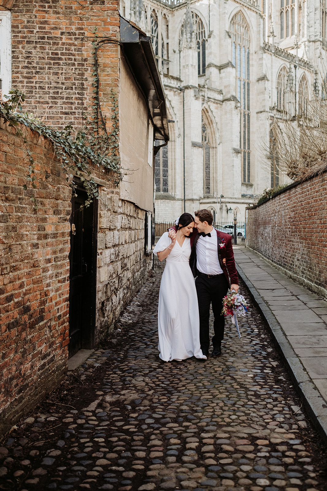 Couple on the cobbled street of York for their Winter City Elopement with hydrangea bouquet