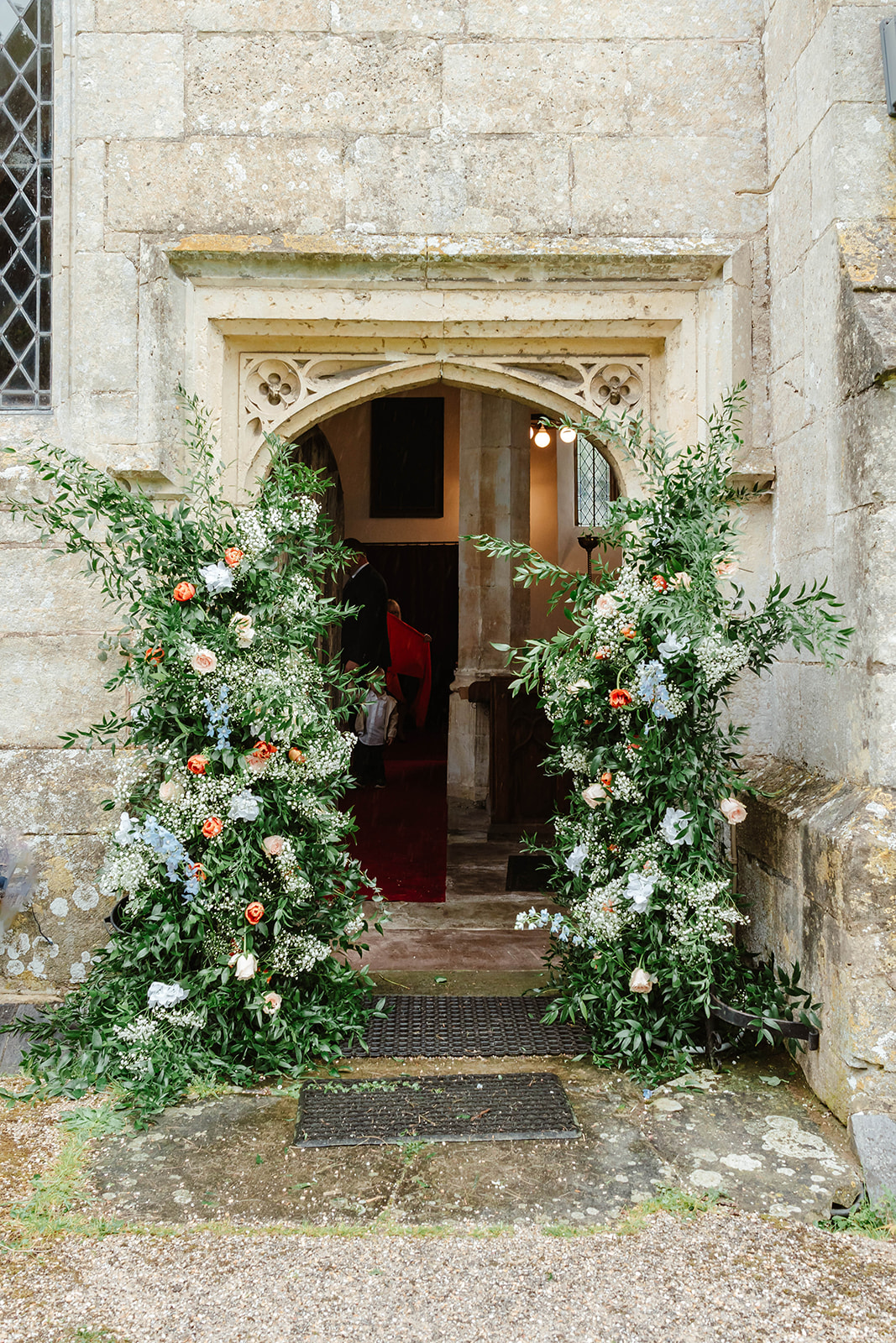 Zara Davis Wedding Photography Moor Farm Moreton Valance Gloucestershire Cotswolds church entrance broken arch flowers