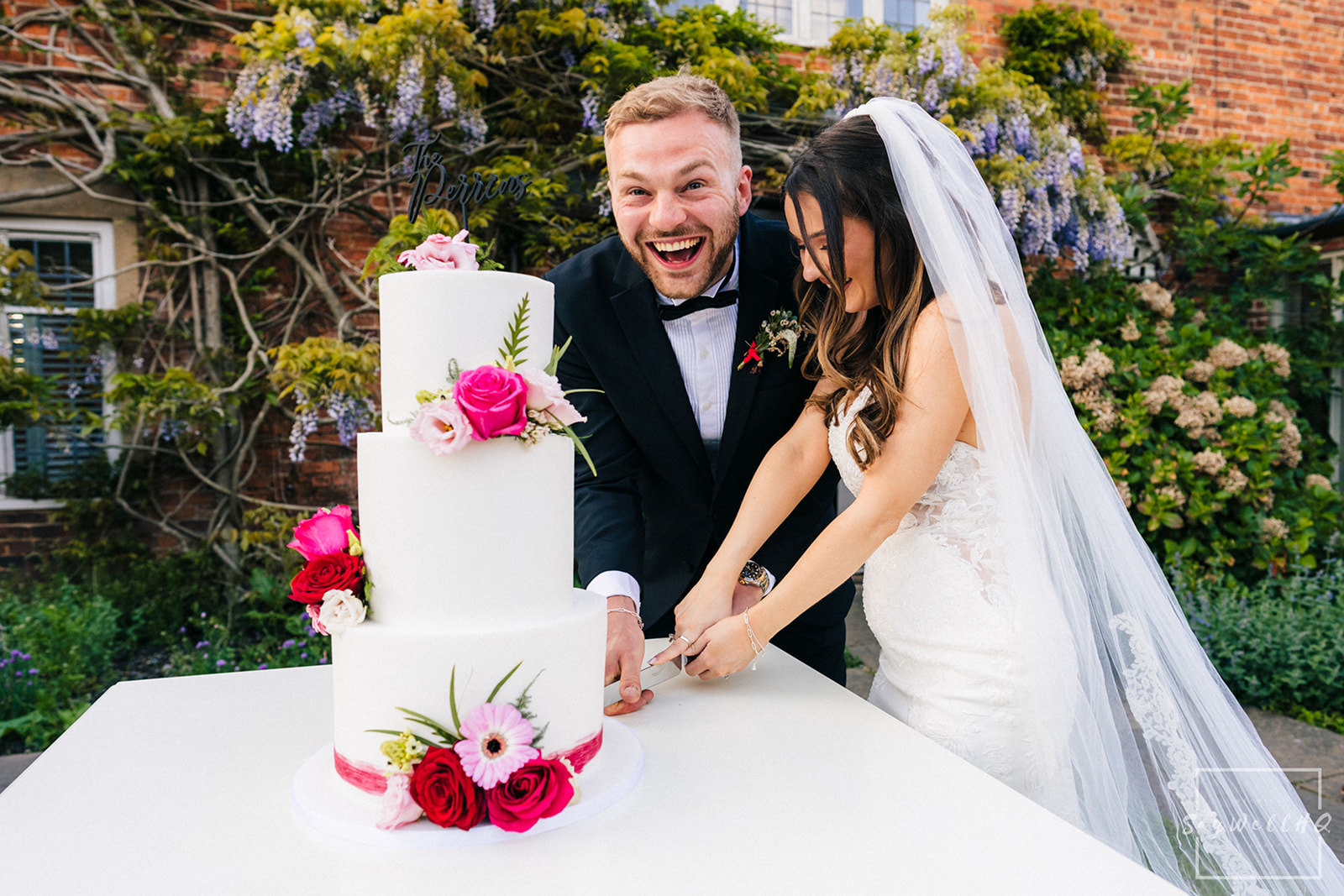 Documentary Wedding Photography Portfolio - bride and groom cutting the wedding cake in the gardens of the wedding venue