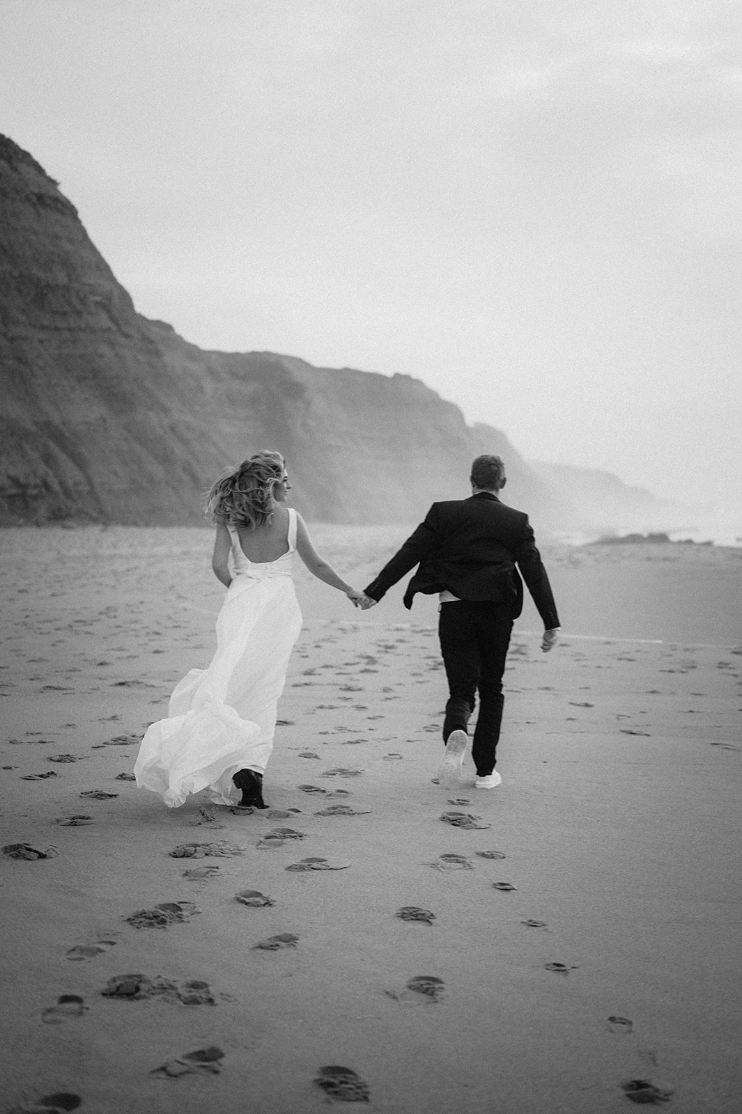Brautpaar läuft am Strand von Portugal