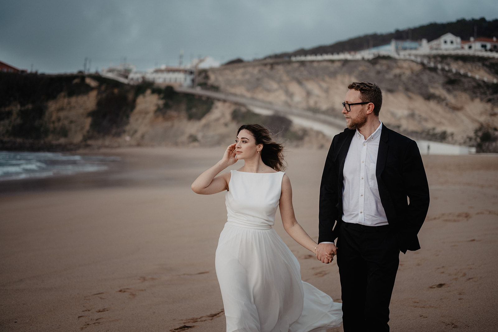 Brautpaar spaziert am Strand von Portugal