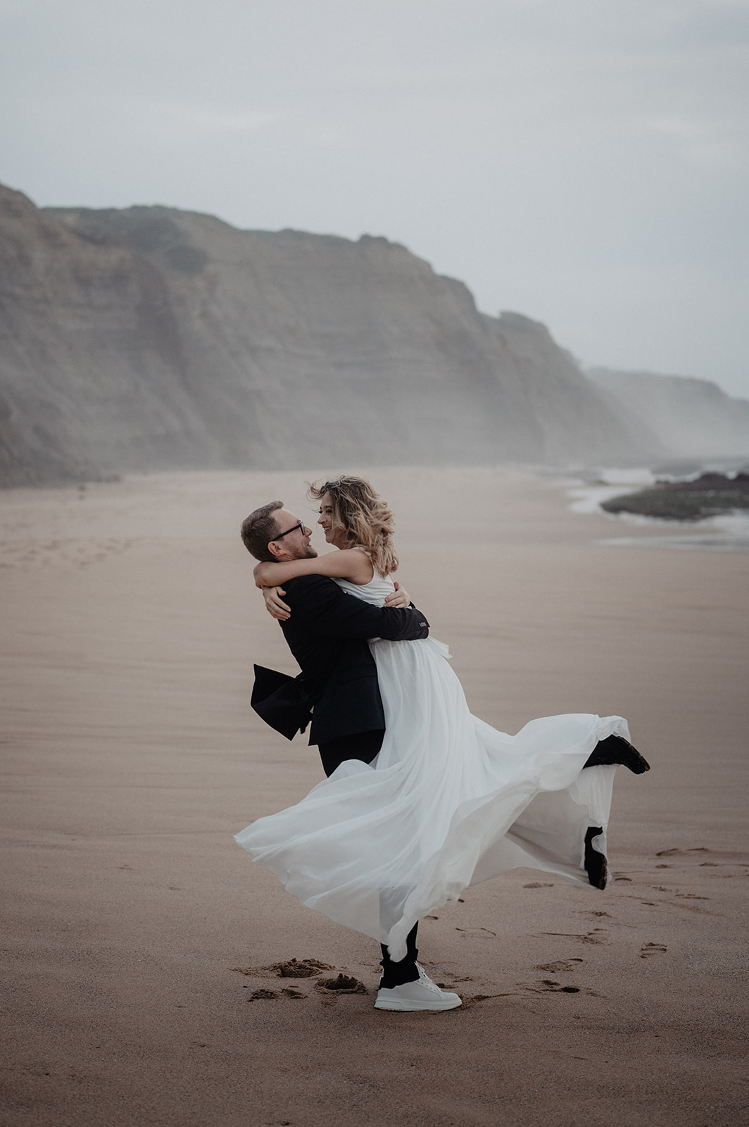 Brautpaar tanzt am Strand von Portugal