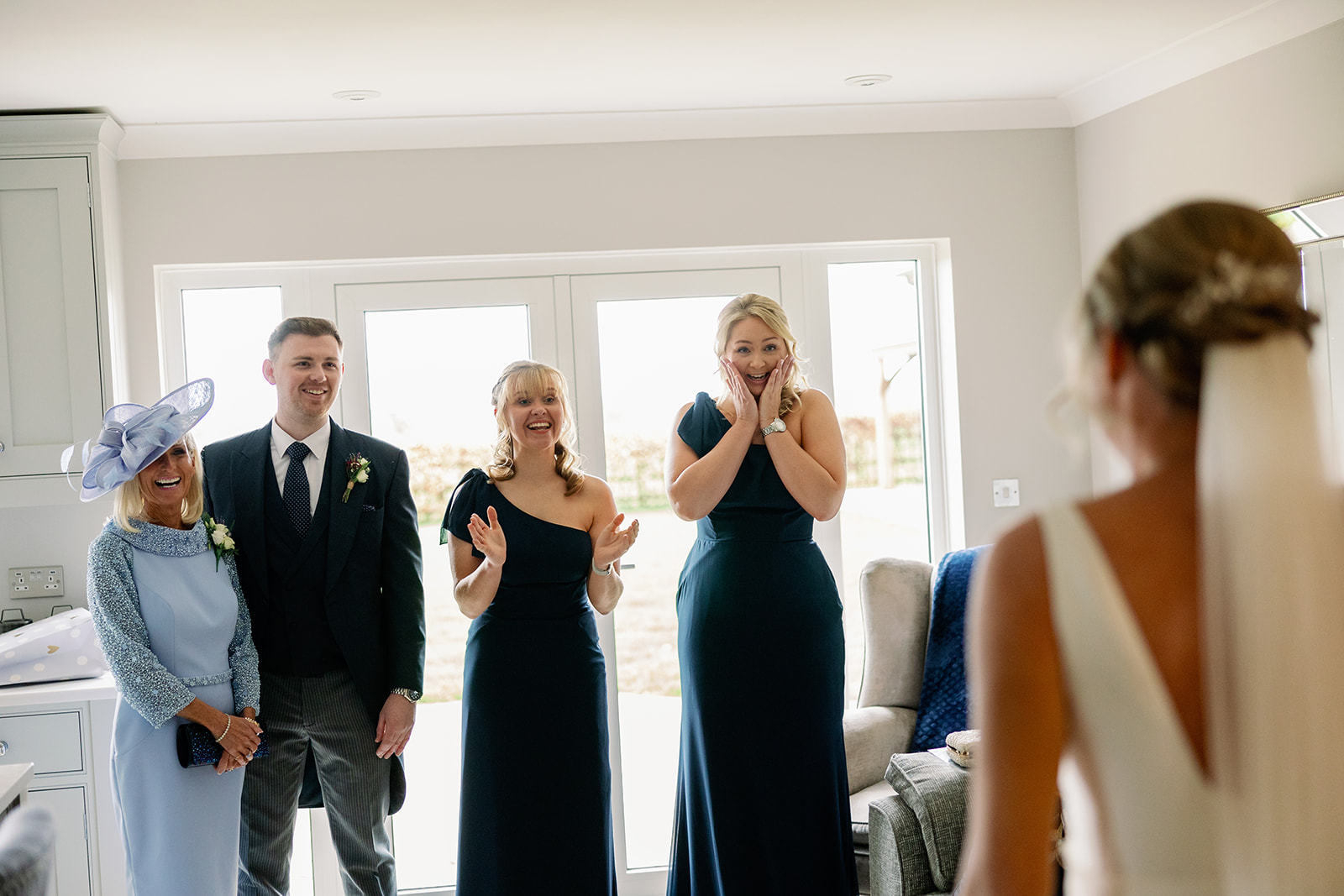 mum, brother and bridesmaids looking blown away after seeing the bride for the first time in her wedding dress 