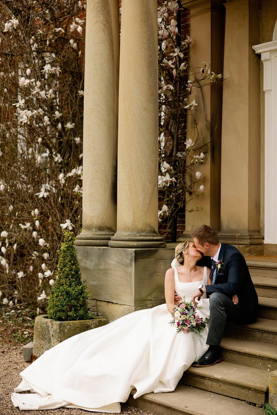 wedding couple kissing on the main steps of Iscoyd Park