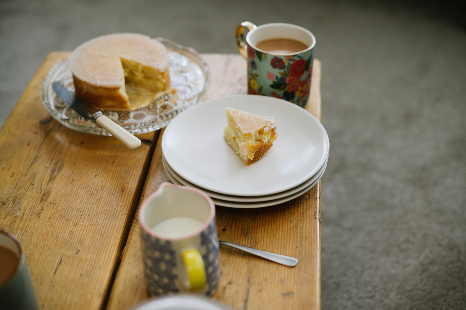 details of cake and tea cups on a wooden table