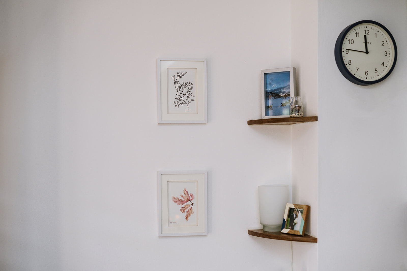 pictures, shelves and a clock hanging on the wall