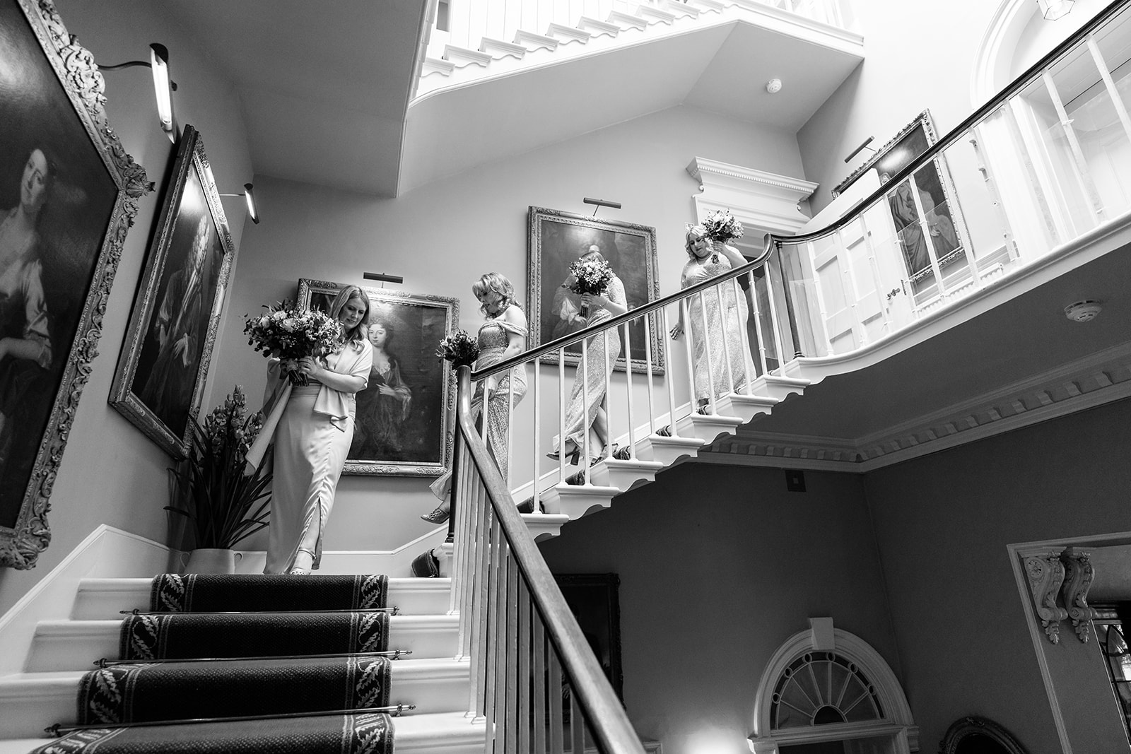 The bridesmaids are walking down the staircase at Norwood Park