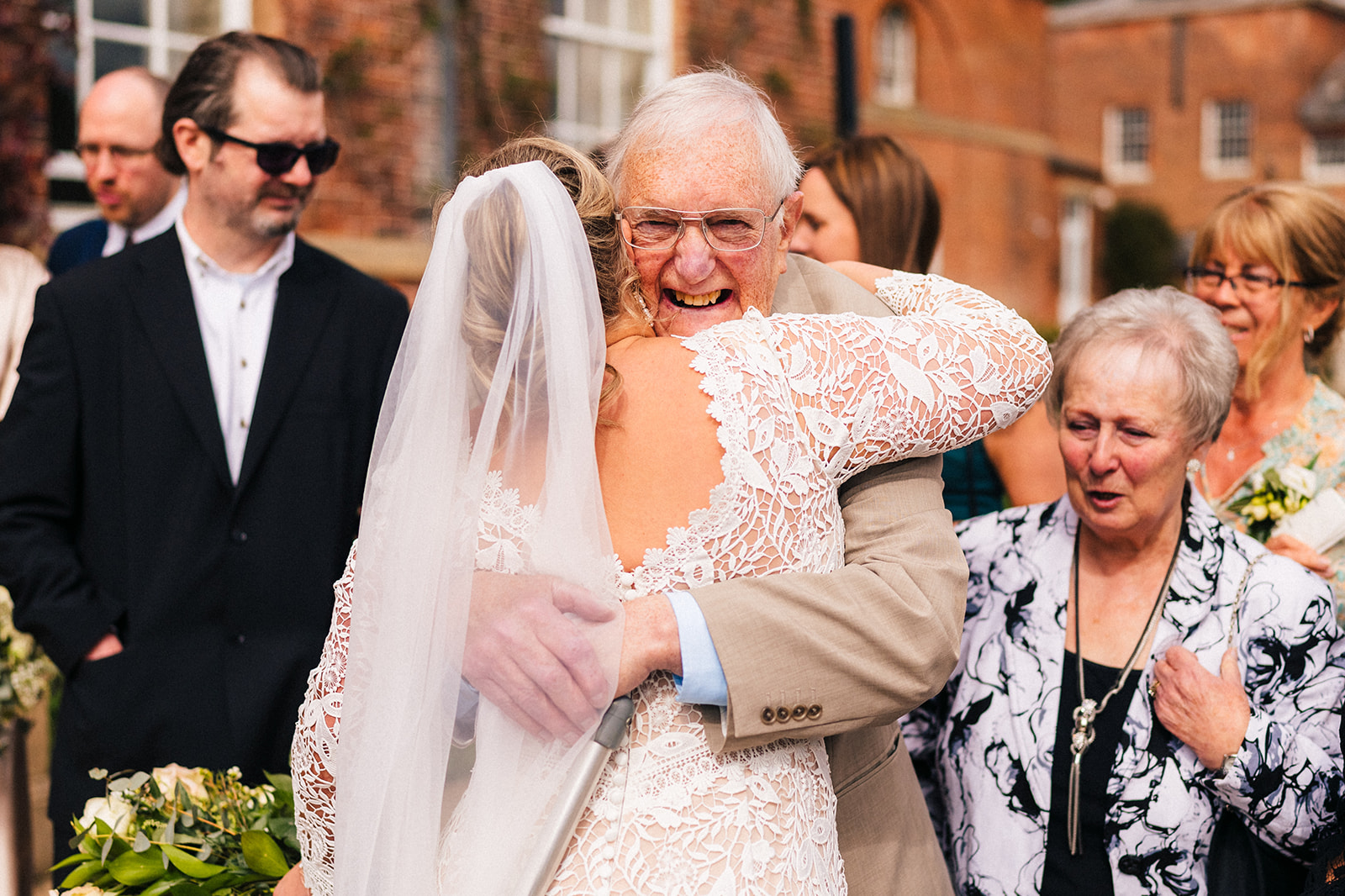 The bride hugging an elderly wedding guest