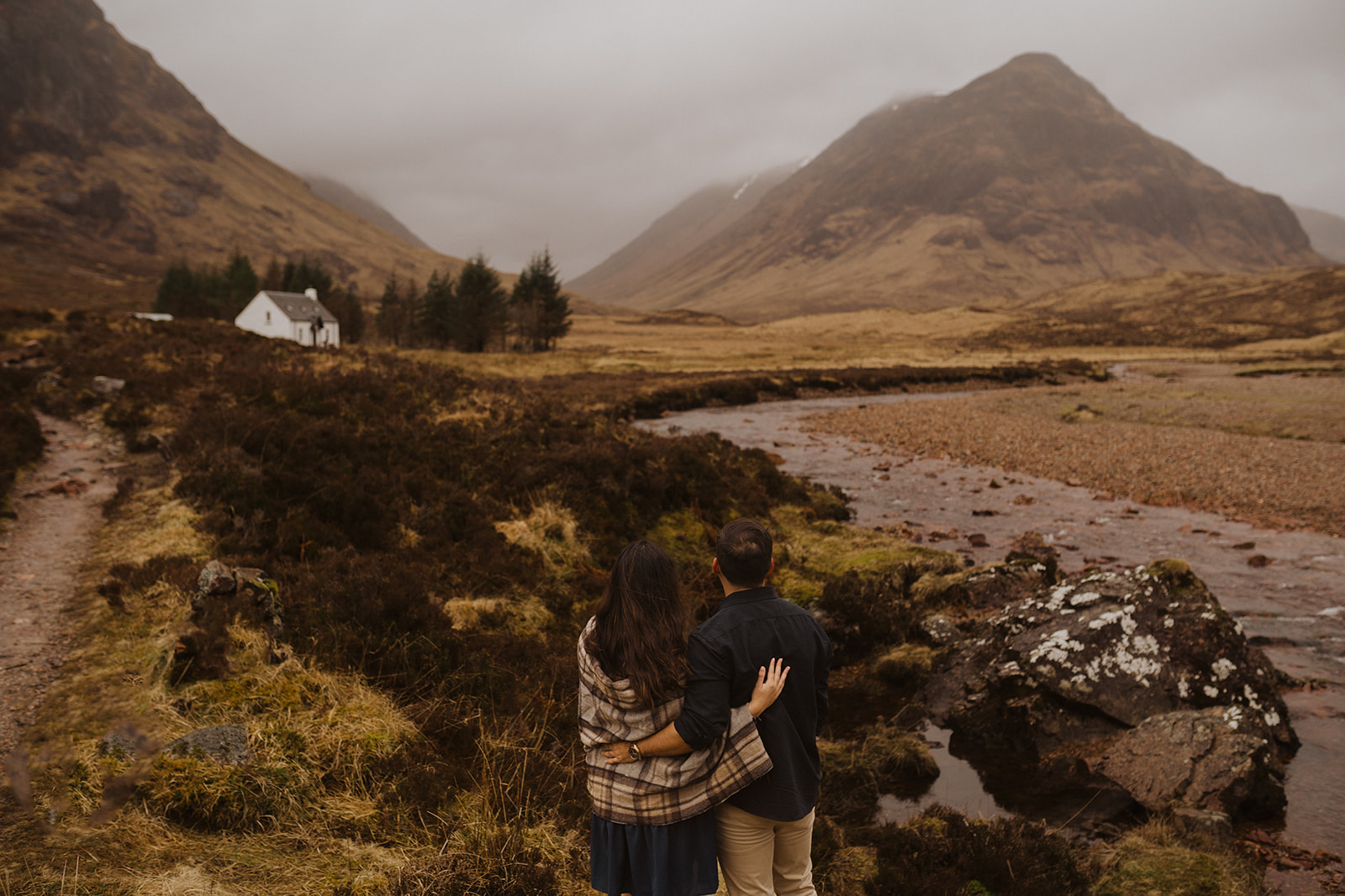 A couple at the White House in Glencoe after getting engaged wear a tartan blanket