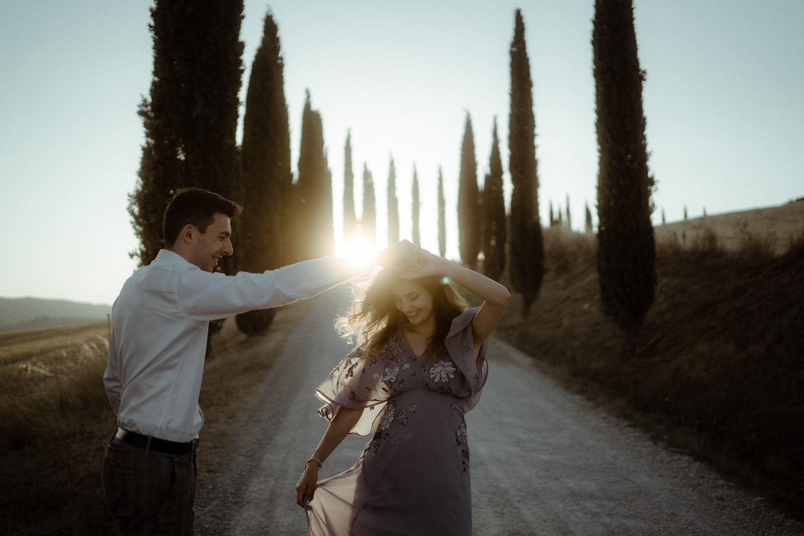 Paar tanzt in einer Zypressenallee in der Toskana in Italien im Val D'Orcia