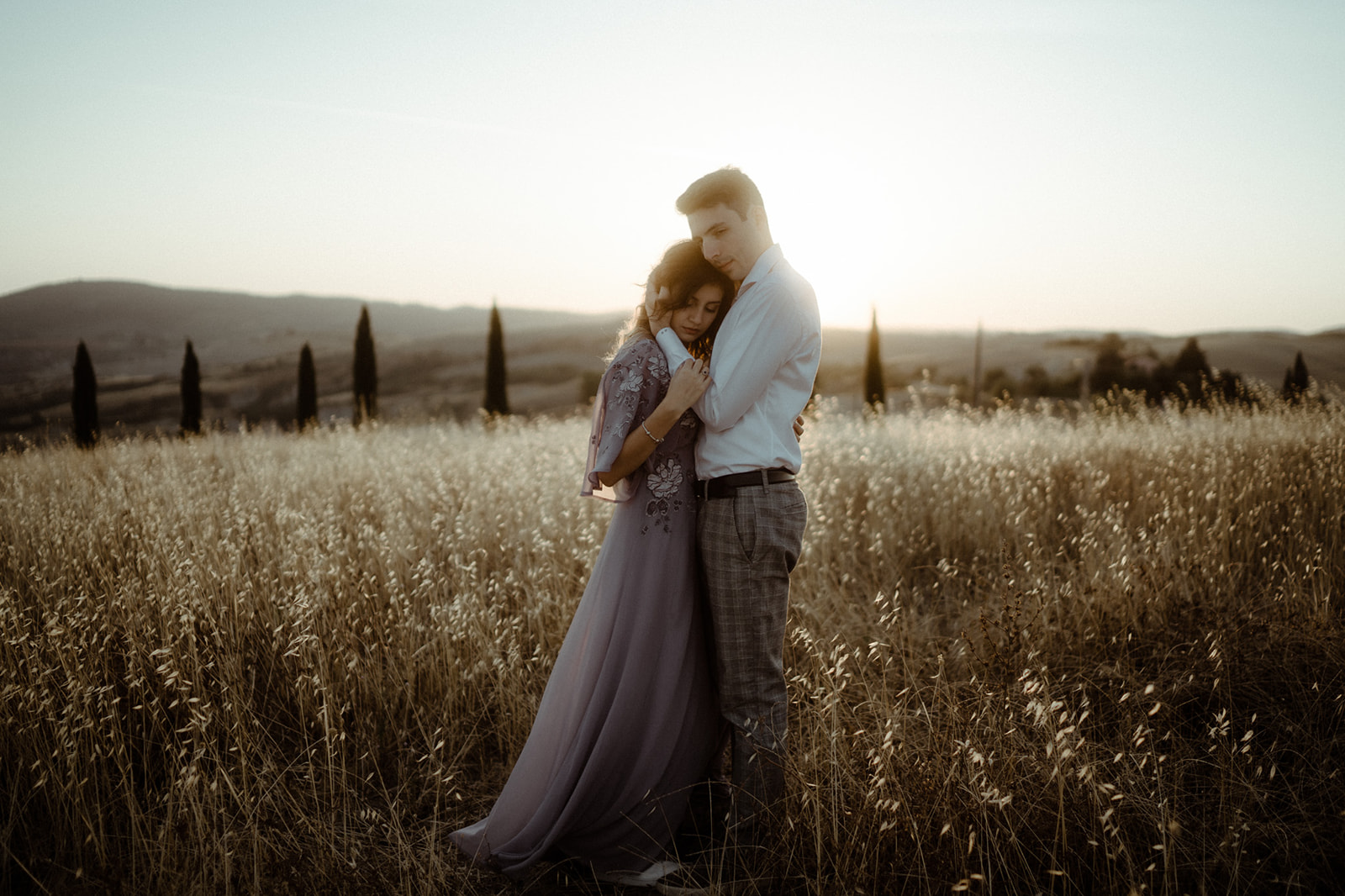 Paar umarmt sich in den Feldern in der Toskana bei einem Fotoshooting in Val D'Orcia