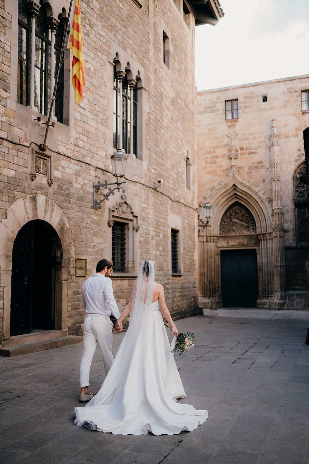Bride and groom walking through the gothic quarter