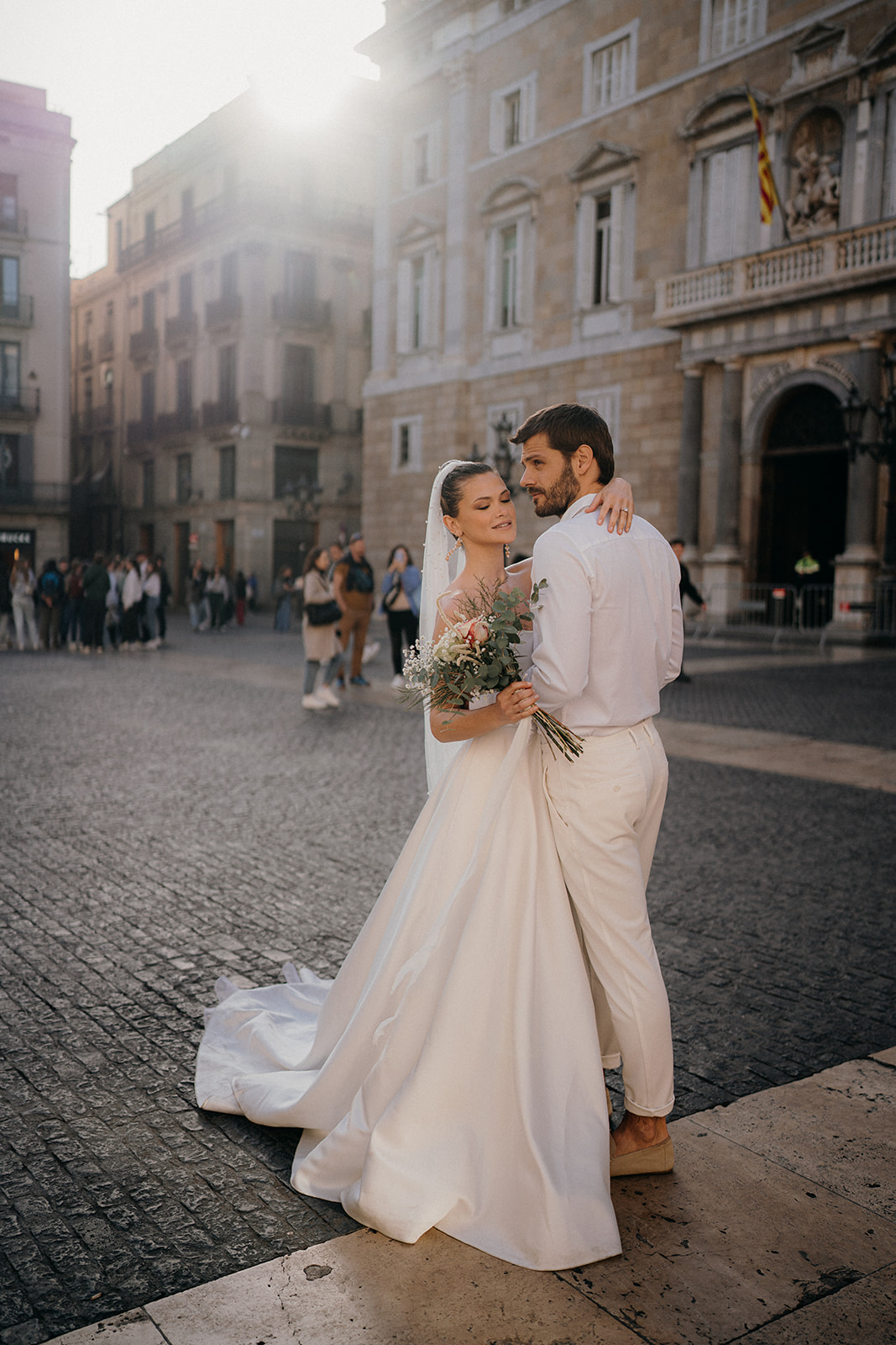 Golden hour soft glowing light hitting couple whilst they cuddle in Barcelona square