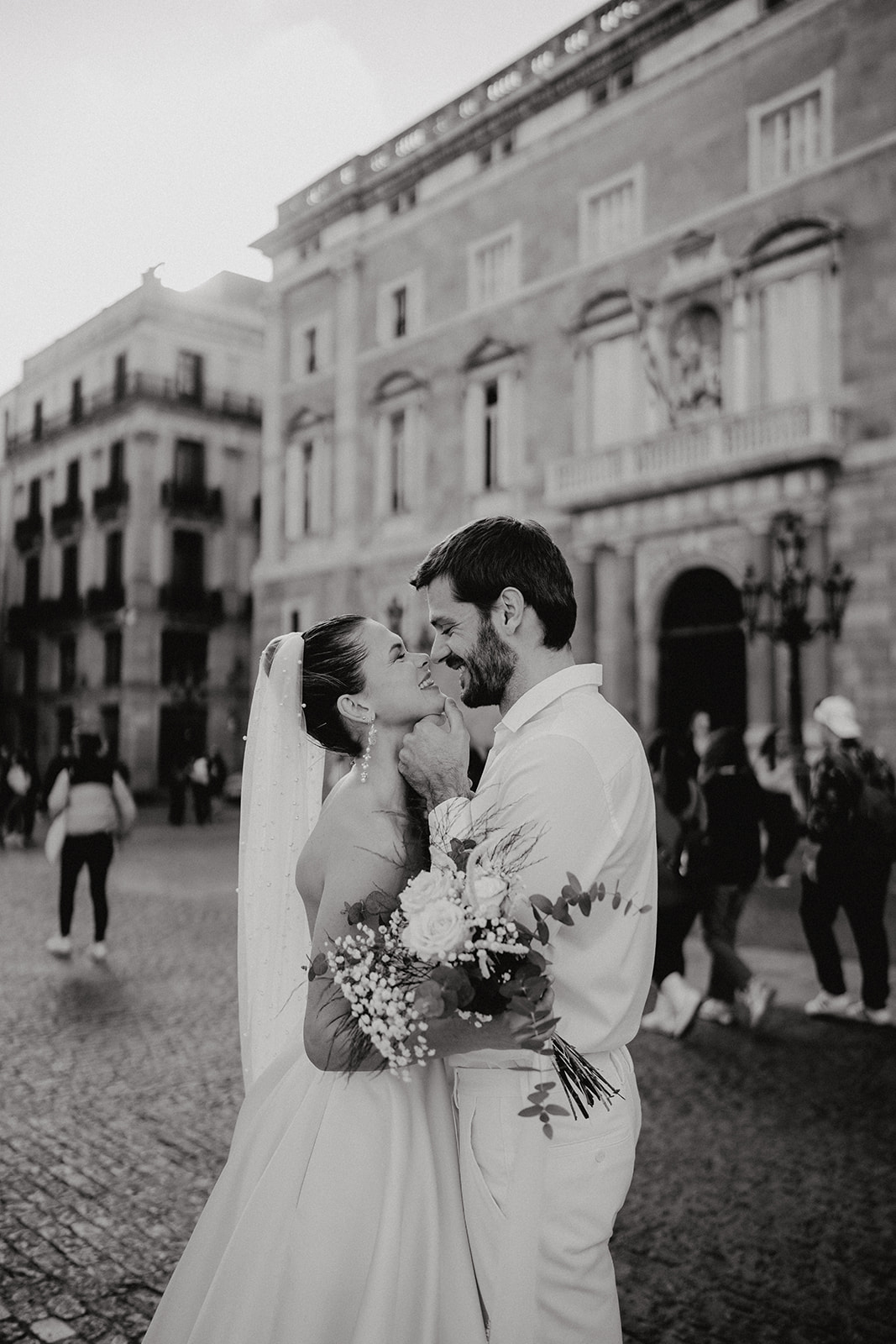 Golden hour soft glowing light hitting couple whilst they cuddle in Barcelona square
