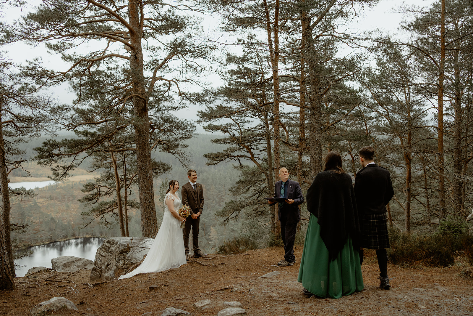 Small Humanist Ceremony with couple getting married amongst the trees with mountains and lochs in the background.