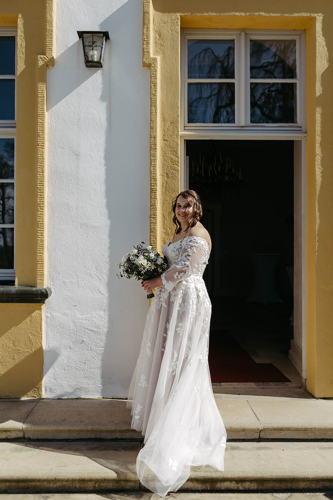 Anmutiges Portrait: Die Braut strahlt vor der beeindruckenden Kulisse des Schlosses Jägersburg