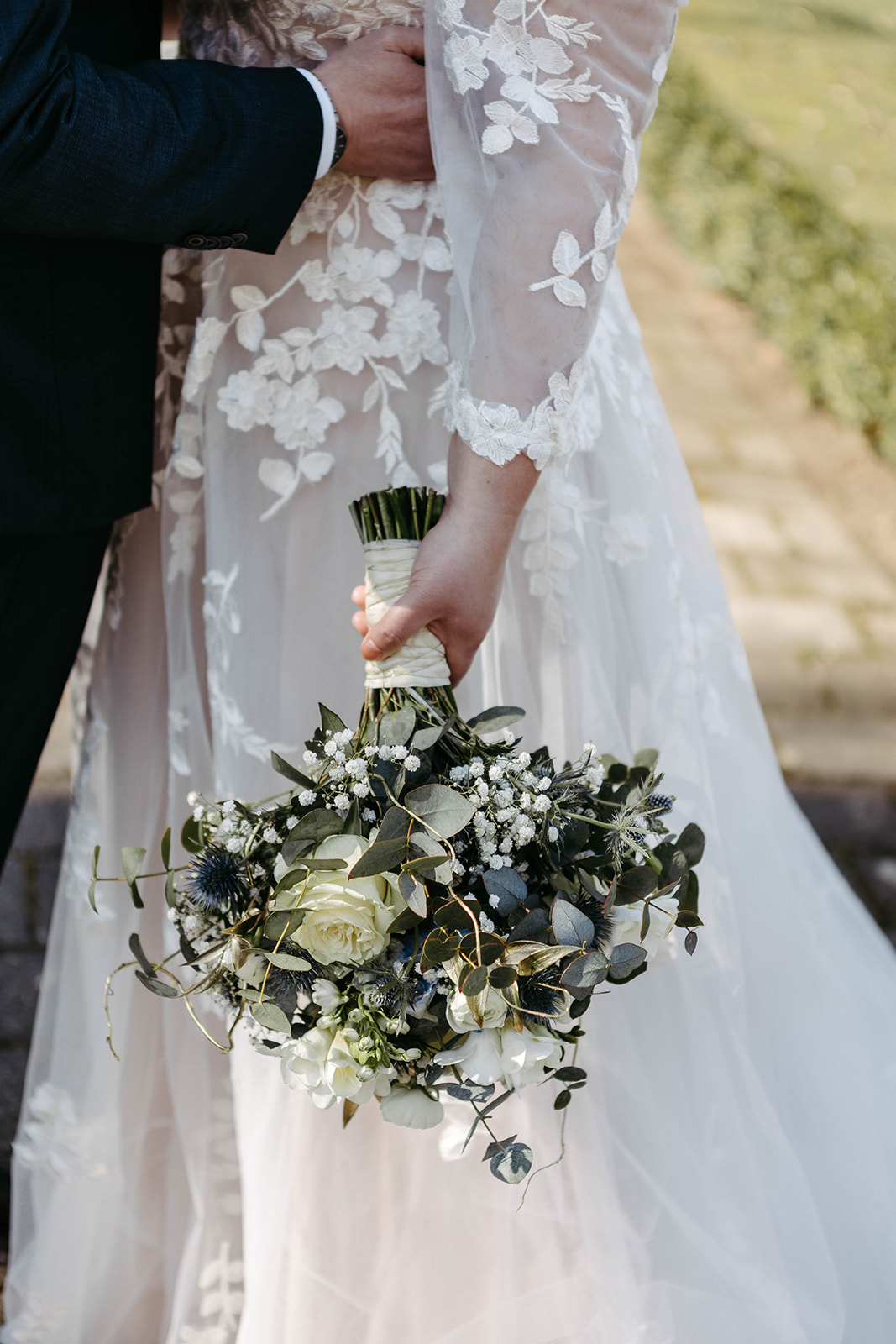 Harmonisches Arrangement: Der Brautstrauß setzt einen blumigen Akzent vor dem eleganten Brautkleid im Schloss Jägersburg