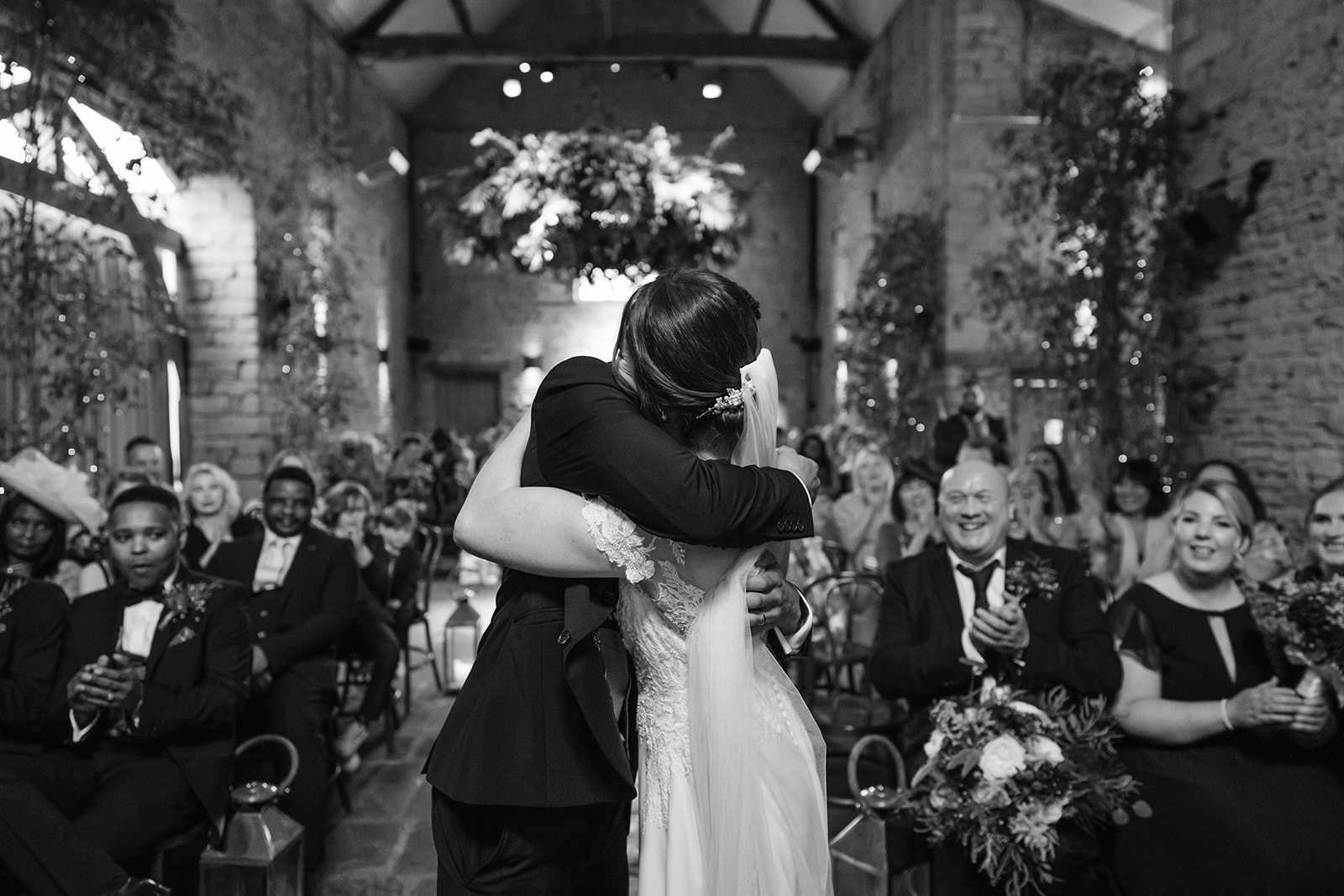 Black and white photo of bride and groom embracing